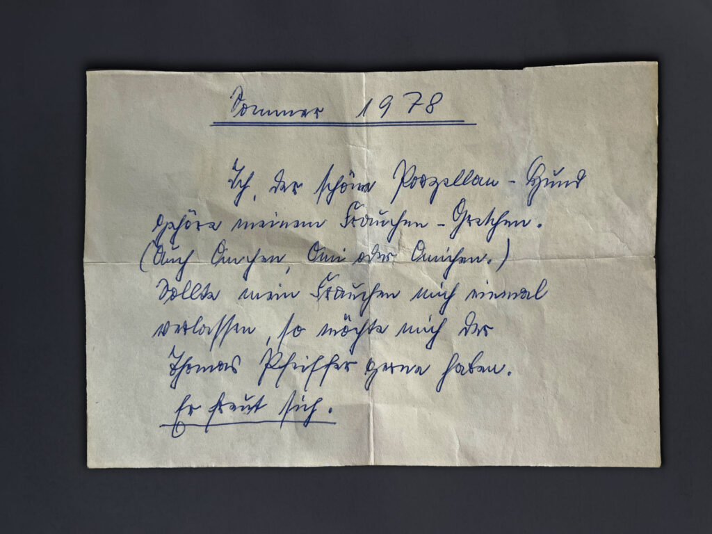 Text auf dem Zettel: Sommer 1978. Ich, der schöne Porzellan-Hund gehöre meinem Frauchen-Gretchen (Auch Omchen, Omi oder Omichen.) Sollte mein Frauchen mich einmal verlassen, so möchte mich der Thomas Pfeiffer gerne haben. Er freut sich. Text auf dem Zettel:
Sommer 1978.
Ich, der schöne Porzellan-Hund gehöre meinem Frauchen-Gretchen (Auch Omchen, Omi oder Omichen.) Sollte mein Frauchen mich einmal verlassen, so möchte mich der Thomas Pfeiffer gerne haben. Er freut sich.